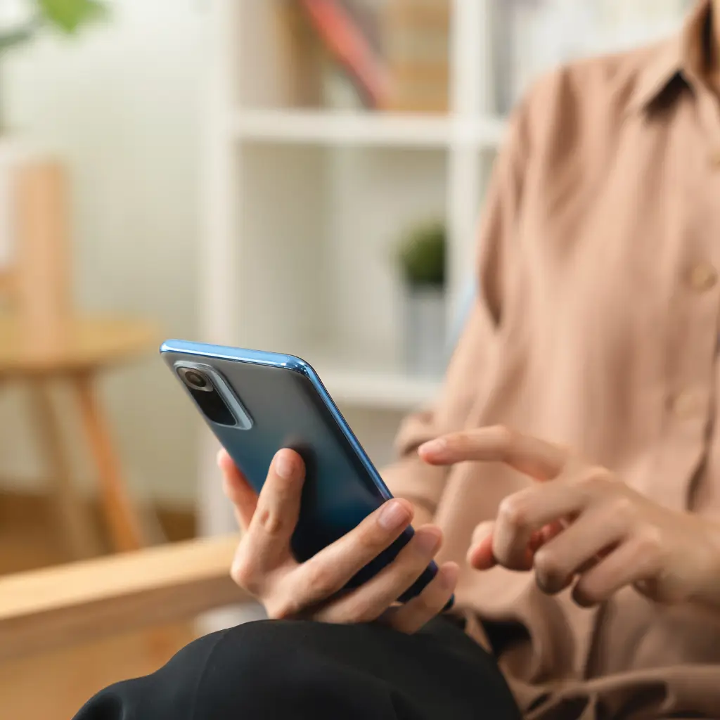 A person holding a mobile phone and in the process of getting in touch with Fit Certify